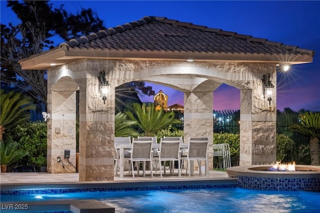 9301 Verlaine Ct, Las Vegas, NV 89145 - pool at night featuring an outdoor fire pit, a patio, and an outdoor pool