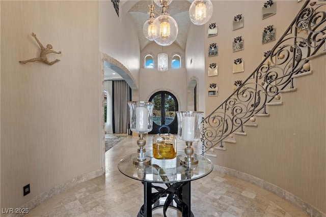 9301 Verlaine Ct, Las Vegas, NV 89145 - foyer featuring a towering ceiling, stairway, arched walkways, a notable chandelier, and baseboards