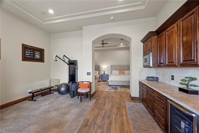 9301 Verlaine Ct, Las Vegas, NV 89145 - exercise room featuring wine cooler, a tray ceiling, a ceiling fan, and wood finished floors