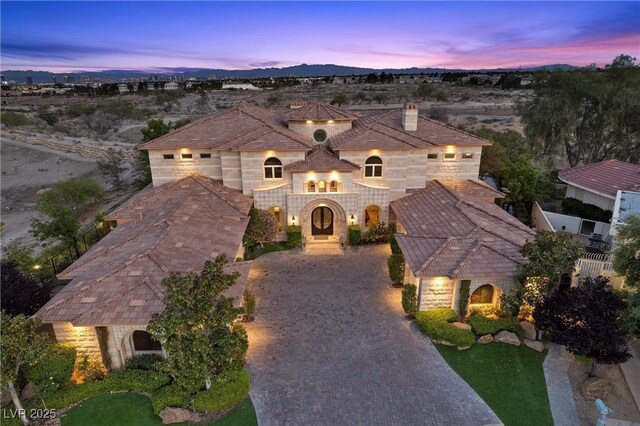 9301 Verlaine Ct, Las Vegas, NV 89145 - view of front of property featuring a chimney, stone siding, and decorative driveway