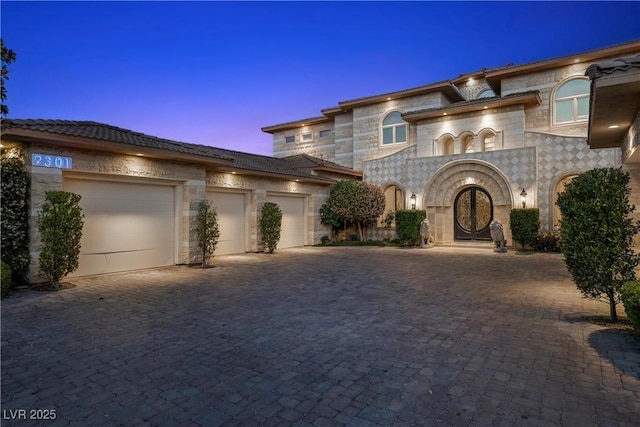 9301 Verlaine Ct, Las Vegas, NV 89145 - view of front of home with an attached garage, decorative driveway, and stone siding