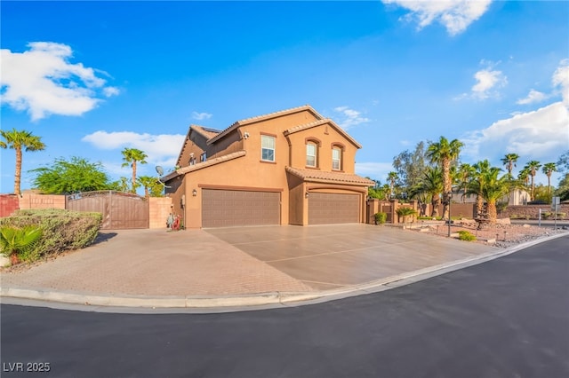 4200 Scott Peak Ct, Las Vegas, NV 89129 - mediterranean / spanish-style home featuring a gate, concrete driveway, a tiled roof, an attached garage, and stucco siding