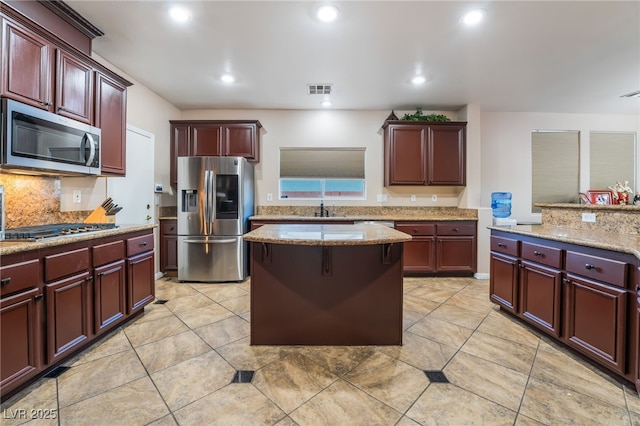 4200 Scott Peak Ct, Las Vegas, NV 89129 - kitchen featuring stainless steel appliances, reddish brown cabinets, tasteful backsplash, light tile patterned floors, and recessed lighting