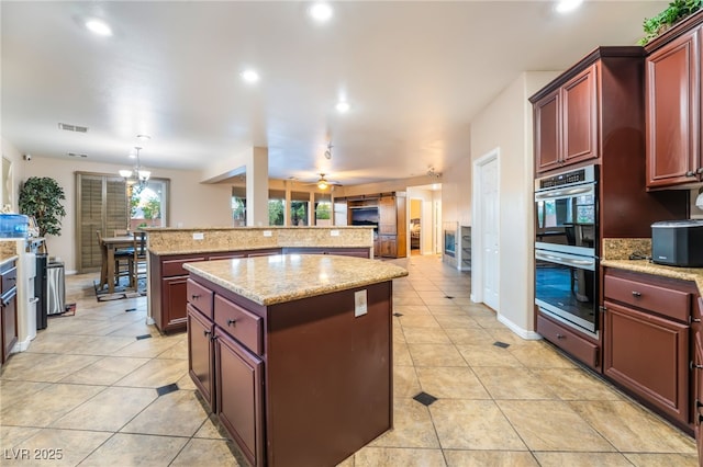 4200 Scott Peak Ct, Las Vegas, NV 89129 - kitchen featuring a center island, stainless steel double oven, light tile patterned floors, dark brown cabinets, and recessed lighting