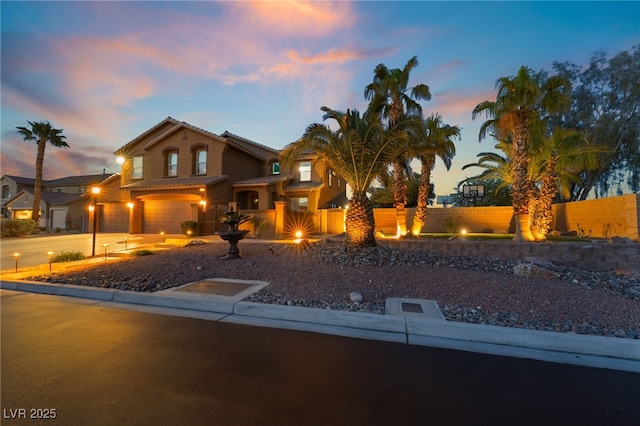 4200 Scott Peak Ct, Las Vegas, NV 89129 - mediterranean / spanish home featuring an attached garage, fence, stucco siding, and a tile roof