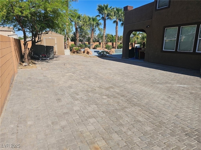 4200 Scott Peak Ct, Las Vegas, NV 89129 - fenced backyard featuring a storage unit, an outdoor structure, and a patio