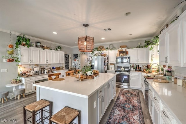 kitchen featuring light countertops, a sink, stainless steel appliances, and decorative backsplash