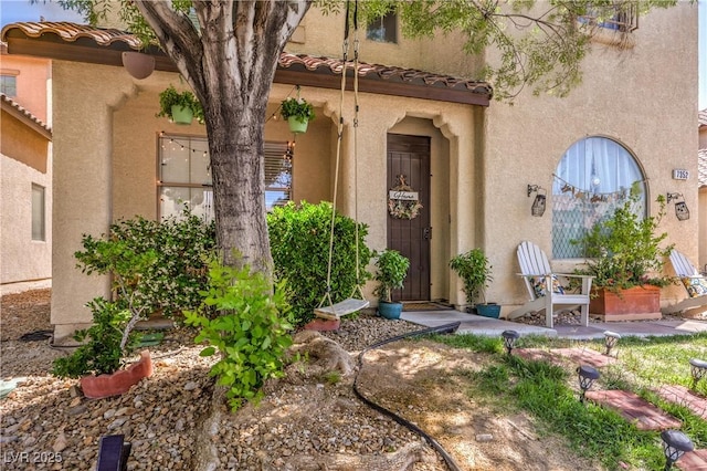 property entrance featuring stucco siding and a tile roof