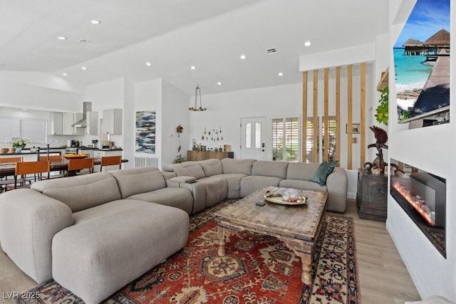 3024 Lotus Hill Dr, Las Vegas, NV 89134 - living area featuring light wood-type flooring, recessed lighting, high vaulted ceiling, and a glass covered fireplace