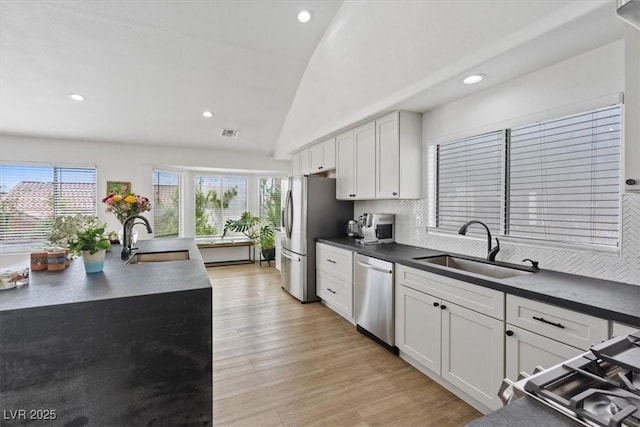 3024 Lotus Hill Dr, Las Vegas, NV 89134 - kitchen featuring stainless steel appliances, a sink, dark countertops, lofted ceiling, and plenty of natural light