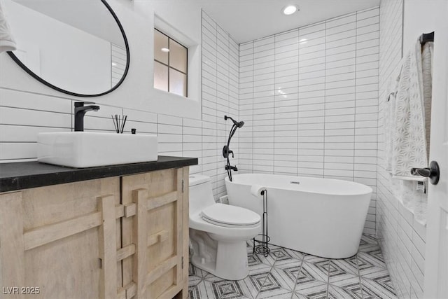 3024 Lotus Hill Dr, Las Vegas, NV 89134 - full bathroom featuring tile walls, a soaking tub, toilet, vanity, and tile patterned flooring