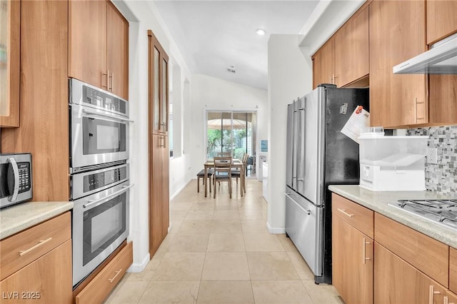 465 Indigo Springs St, Henderson, NV 89014 - kitchen with decorative backsplash, light tile patterned flooring, light countertops, under cabinet range hood, and appliances with stainless steel finishes