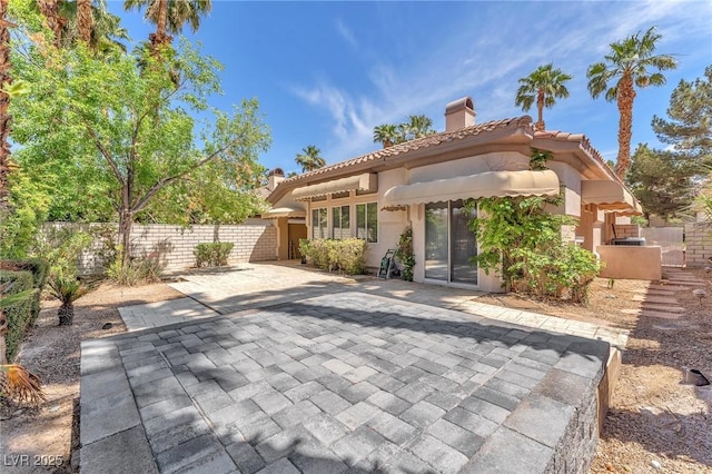 465 Indigo Springs St, Henderson, NV 89014 - view of front facade with fence, a patio, stucco siding, a chimney, and a tiled roof