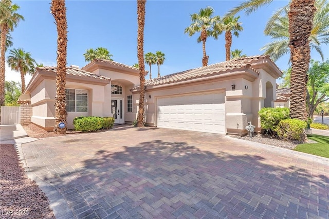 465 Indigo Springs St, Henderson, NV 89014 - mediterranean / spanish home with a tile roof, a garage, stucco siding, decorative driveway, and french doors