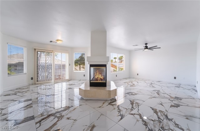 7526 Gossamer Wind St, Las Vegas, NV 89139 - living area featuring a multi sided fireplace, ceiling fan, baseboards, and marble finish floors