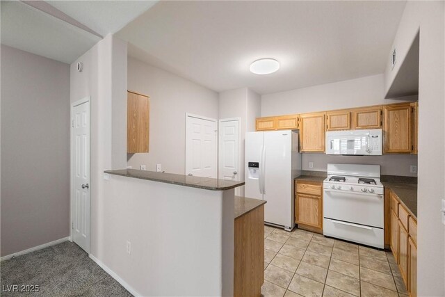 10001 Peace Way Unit 2228, Las Vegas, NV 89147 - kitchen featuring white appliances, dark countertops, and a peninsula