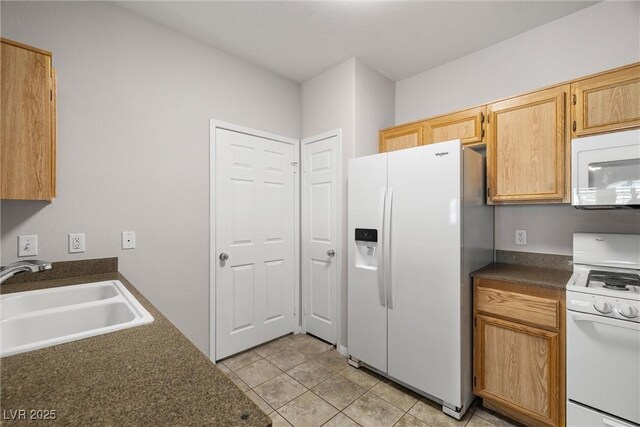 10001 Peace Way Unit 2228, Las Vegas, NV 89147 - kitchen with white appliances, a sink, dark countertops, and light tile patterned floors