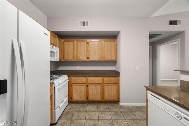 10001 Peace Way Unit 2228, Las Vegas, NV 89147 - kitchen with white appliances, dark countertops, light tile patterned floors, and baseboards