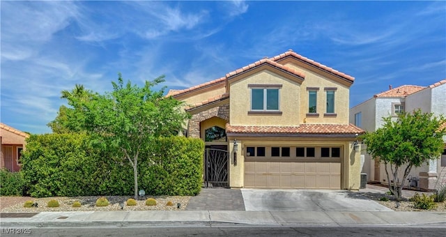 mediterranean / spanish-style house with driveway, stucco siding, an attached garage, and a tile roof