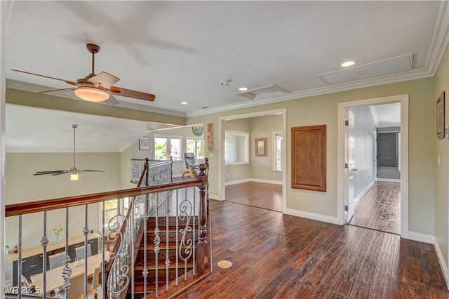 hall with wood finished floors, attic access, ornamental molding, an upstairs landing, and baseboards