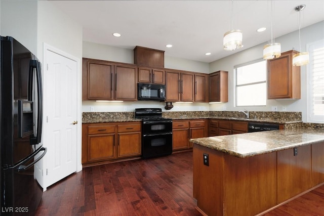 240 Jumping Springs Pl, Henderson, NV 89012 - kitchen featuring black appliances, a peninsula, hanging light fixtures, dark wood-type flooring, and brown cabinets