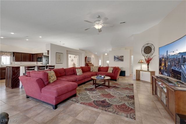 living room with visible vents, light tile patterned floors, ceiling fan, and lofted ceiling