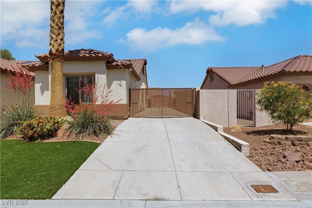 view of home's exterior featuring a gate, driveway, a tiled roof, stucco siding, and fence