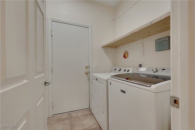 laundry area with light tile patterned floors, washing machine and clothes dryer, and laundry area