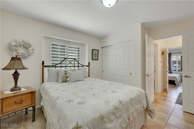 bedroom with light tile patterned floors and a closet