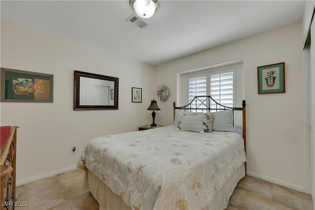 bedroom featuring light tile patterned floors, visible vents, and baseboards