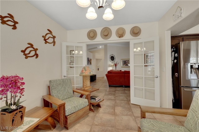 living area with light tile patterned floors, an inviting chandelier, and french doors
