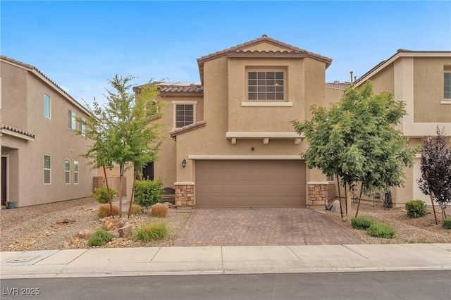 5731 Sedona Springs St, North Las Vegas, NV 89031 - view of front of property with a tiled roof, a garage, stucco siding, decorative driveway, and stone siding