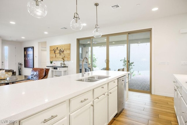kitchen with stainless steel dishwasher, light wood-style flooring, a sink, visible vents, and a healthy amount of sunlight