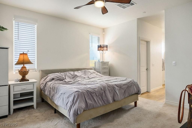 bedroom featuring visible vents, ceiling fan, light carpet, and baseboards