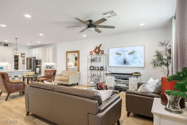 living room featuring visible vents, light wood-type flooring, and recessed lighting