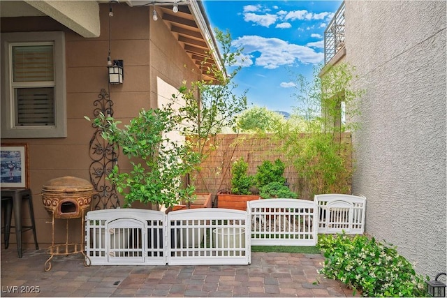view of property exterior with a patio and fence
