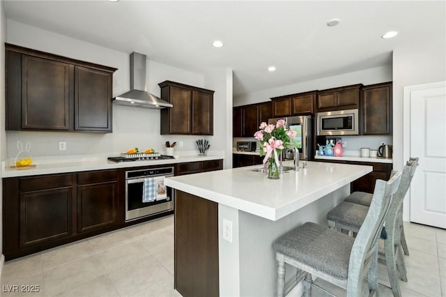 4630 Adonis Blue St, North Las Vegas, NV 89031 - kitchen featuring appliances with stainless steel finishes, wall chimney exhaust hood, a sink, light tile patterned floors, and light countertops