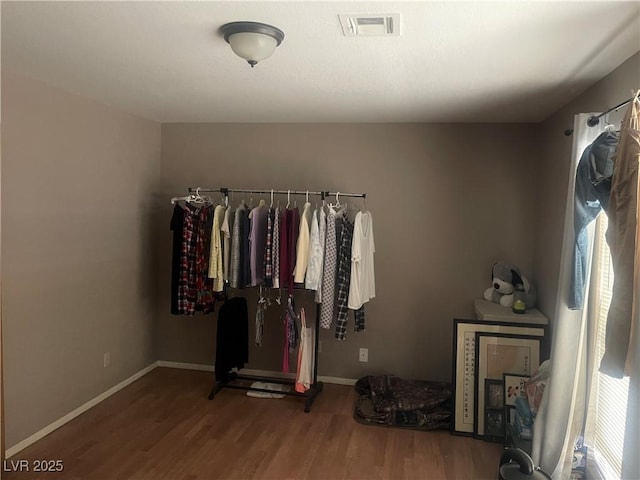 walk in closet with visible vents and wood finished floors