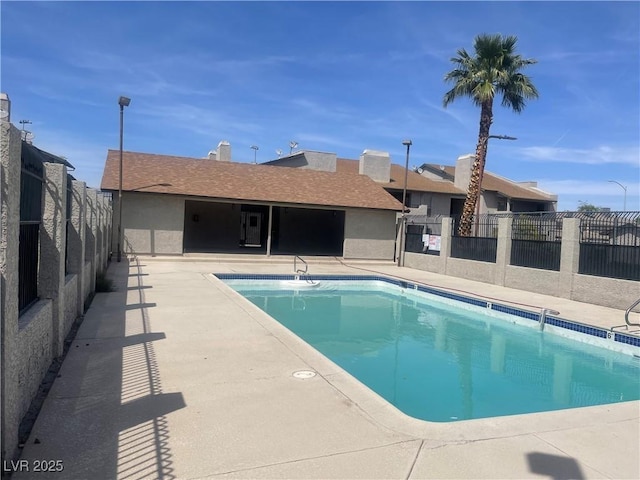 community pool with a patio and fence