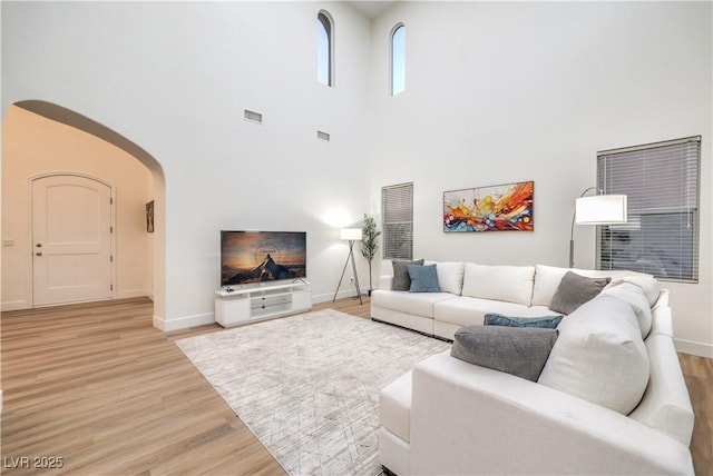 2571 Red Springs Dr, Las Vegas, NV 89135 - living room featuring baseboards, visible vents, light wood-type flooring, and a towering ceiling