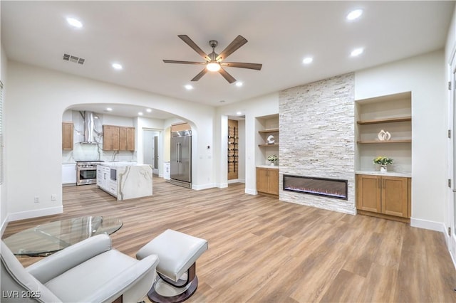 2571 Red Springs Dr, Las Vegas, NV 89135 - living room with visible vents, baseboards, arched walkways, light wood finished floors, and a ceiling fan
