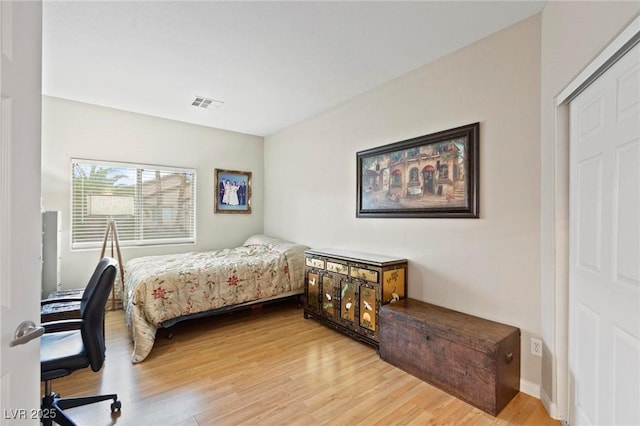 bedroom with light wood-style flooring, baseboards, and visible vents