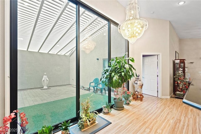 interior space with recessed lighting, a notable chandelier, baseboards, and wood finished floors