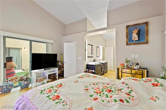 bedroom featuring light wood-style floors and high vaulted ceiling