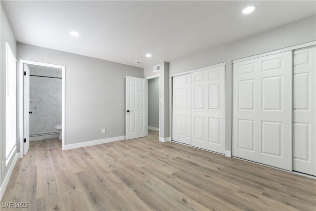 unfurnished bedroom with visible vents, light wood-style floors, baseboards, recessed lighting, and two closets