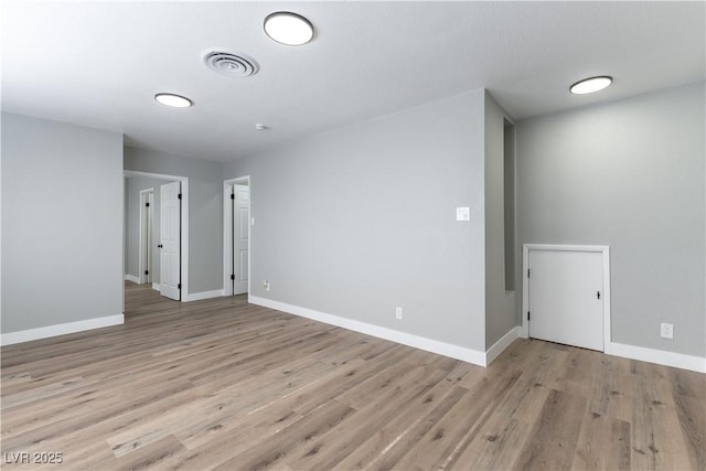 spare room with visible vents, light wood-style floors, and baseboards