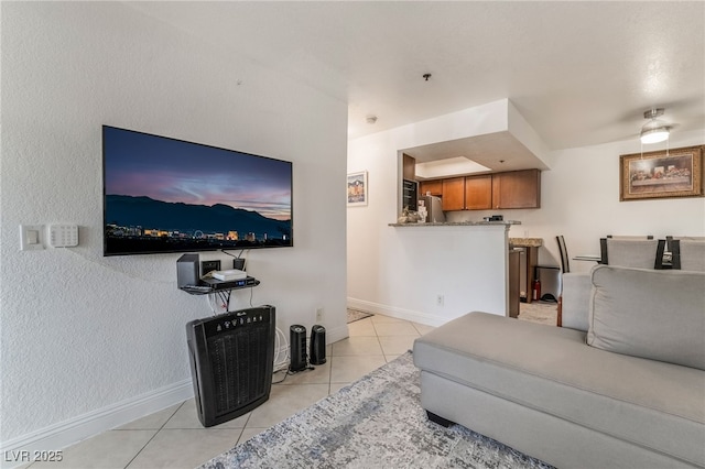 living area featuring baseboards and light tile patterned floors