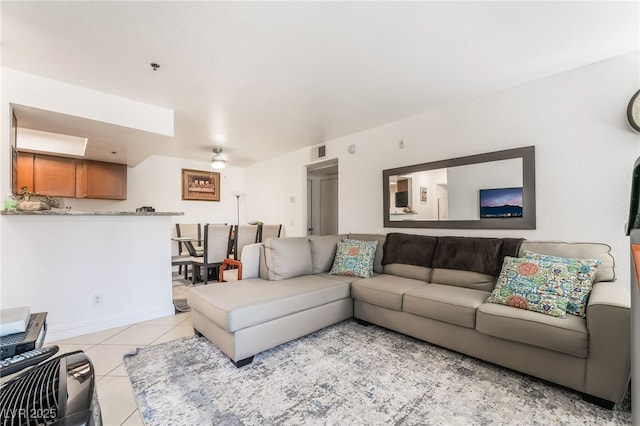 living area with light tile patterned floors, a ceiling fan, and visible vents