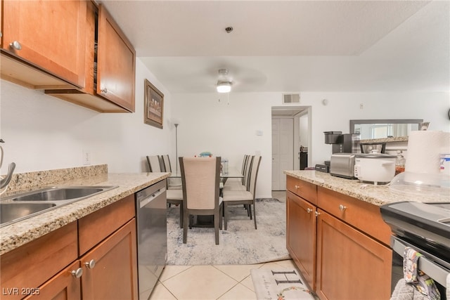 kitchen with brown cabinets, stainless steel appliances, visible vents, and light tile patterned floors