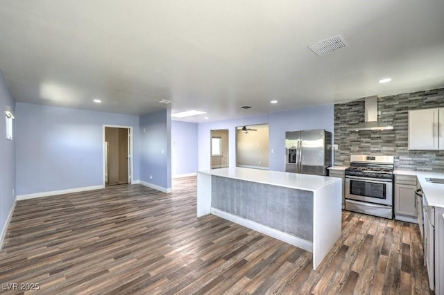417 Wisteria Ave, Las Vegas, NV 89107 - kitchen with appliances with stainless steel finishes, wall chimney range hood, open floor plan, dark wood finished floors, and light countertops